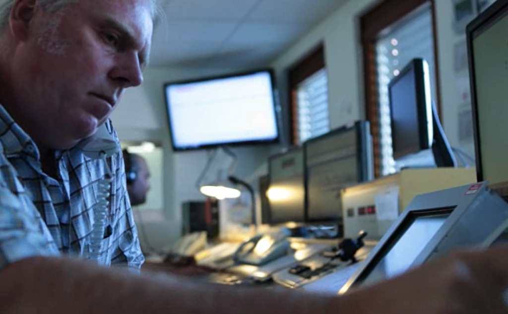 Man working at a monitoring workstation with computer screens